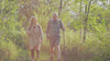 Woman and man in their early 60s rucking with a backpack and poles